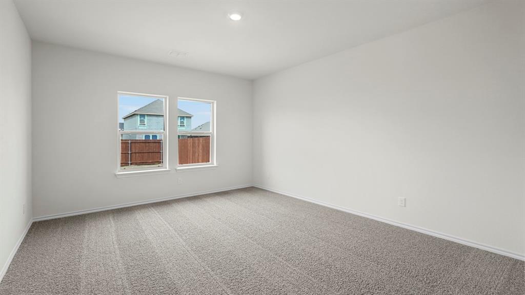 Spacious interior room featuring light gray carpeting, crisp white walls, and two large windows