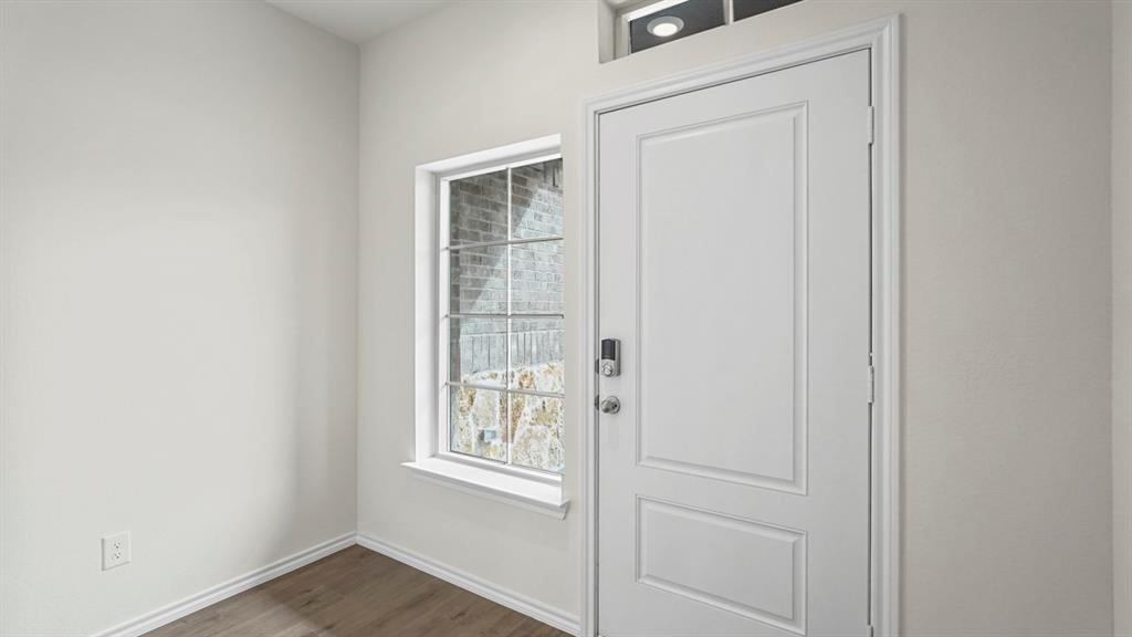 Entryway featuring a paneled door with smart lock hardware, a transom window, and wood-finish flooring