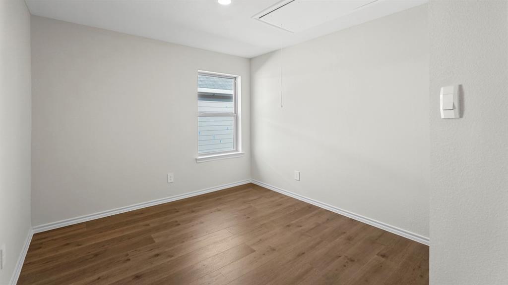 Recessed lighting, wood-finish flooring, white trim, single window, and neutral wall tones