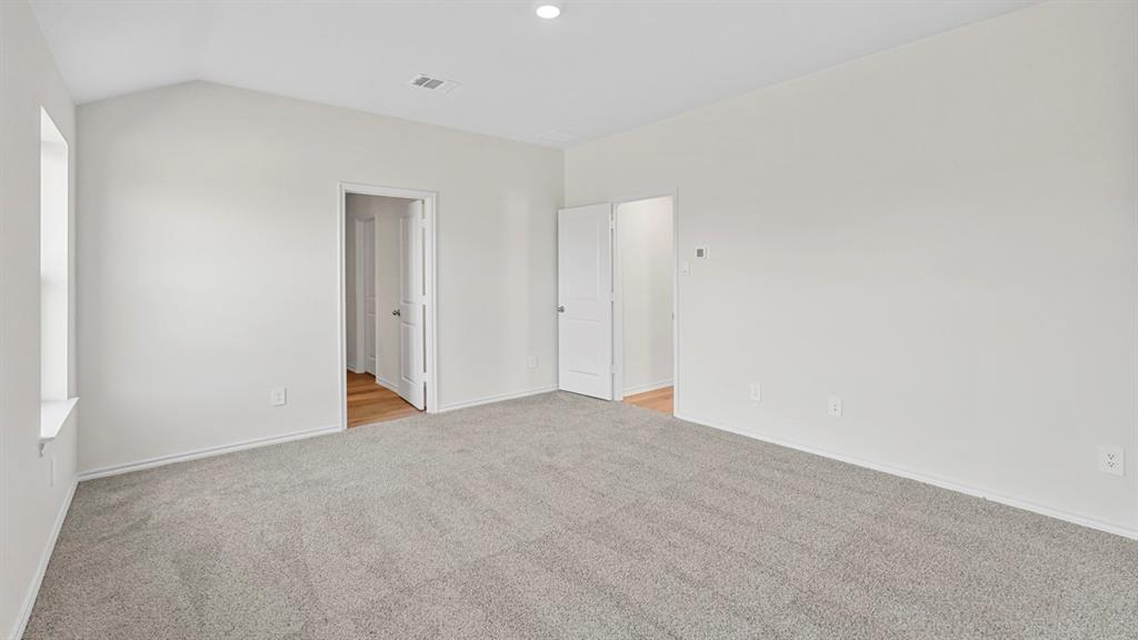 Spacious bedroom with neutral wall finishes, recessed ceiling lighting, and neutral-toned carpet flooring