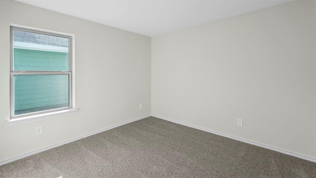 Neutral wall color, gray carpet flooring, and a double-hung window