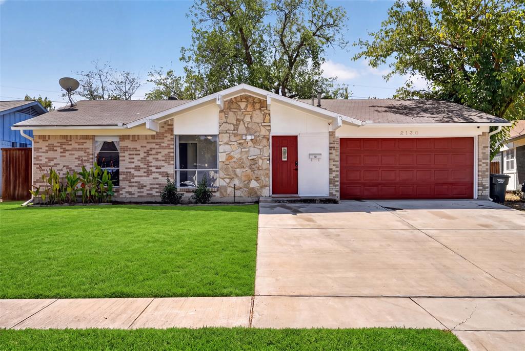 Brick and stone exterior with a prominent red front door and a matching red garage door Brick and stone exterior with a prominent red front door and a matching red garage door