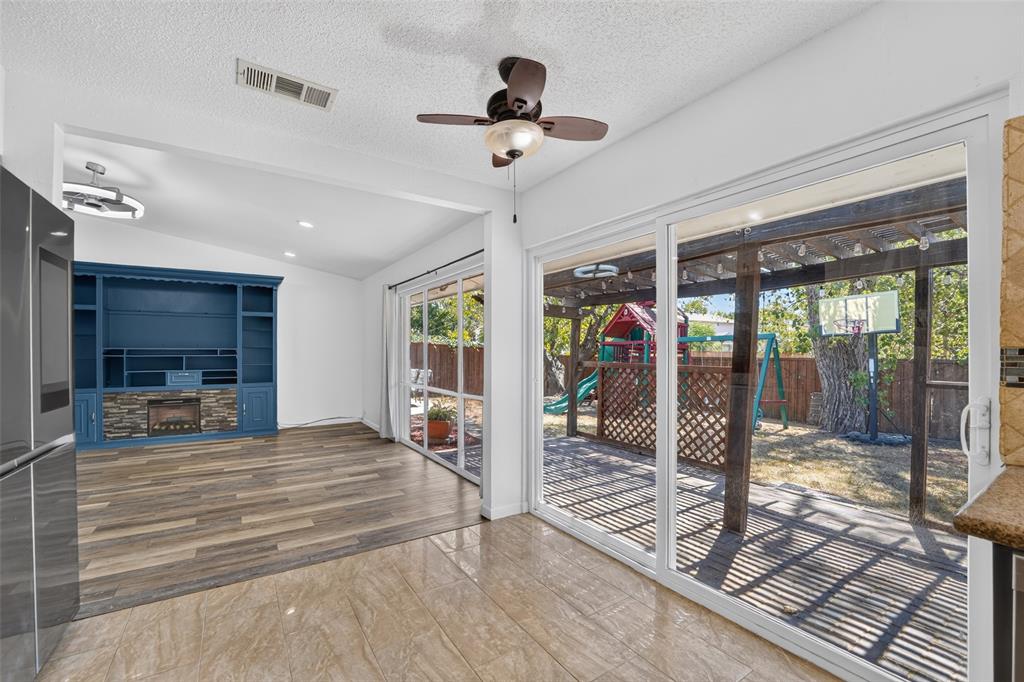 Vaulted ceilings with recessed lighting, wood-finish flooring, and a built-in media center with a stone-finish fireplace