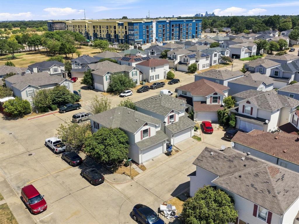 Residential neighborhood featuring multiple single-family homes with attached garages, mature trees, and paved roadways