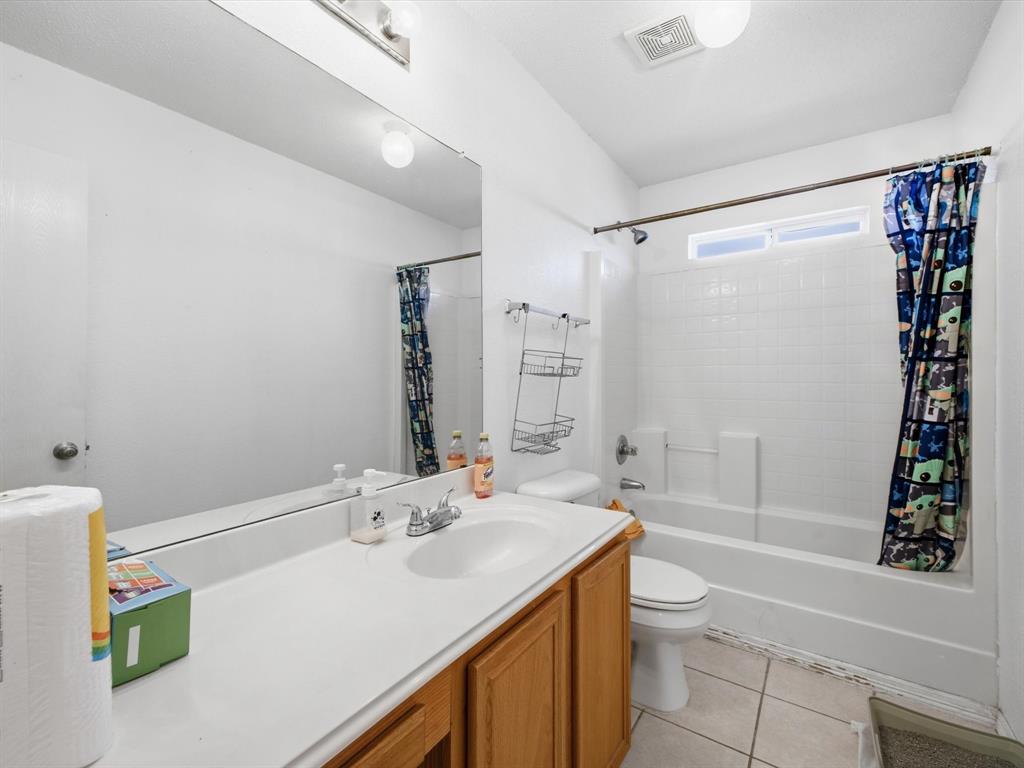 Bathroom featuring a vanity with wood-finish cabinetry, a white countertop, and a white sink