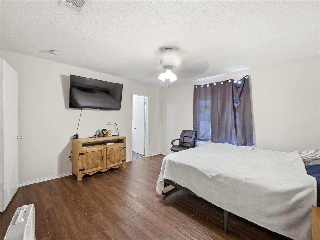 Wood-finish flooring throughout, white walls, and a ceiling-mounted light fixture