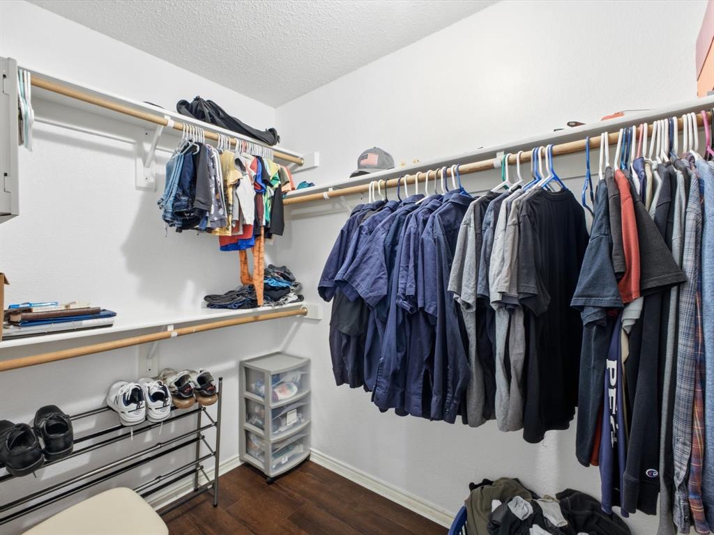 Walk-in closet featuring wood-finish flooring, multiple shelving units, and integrated hanging rods