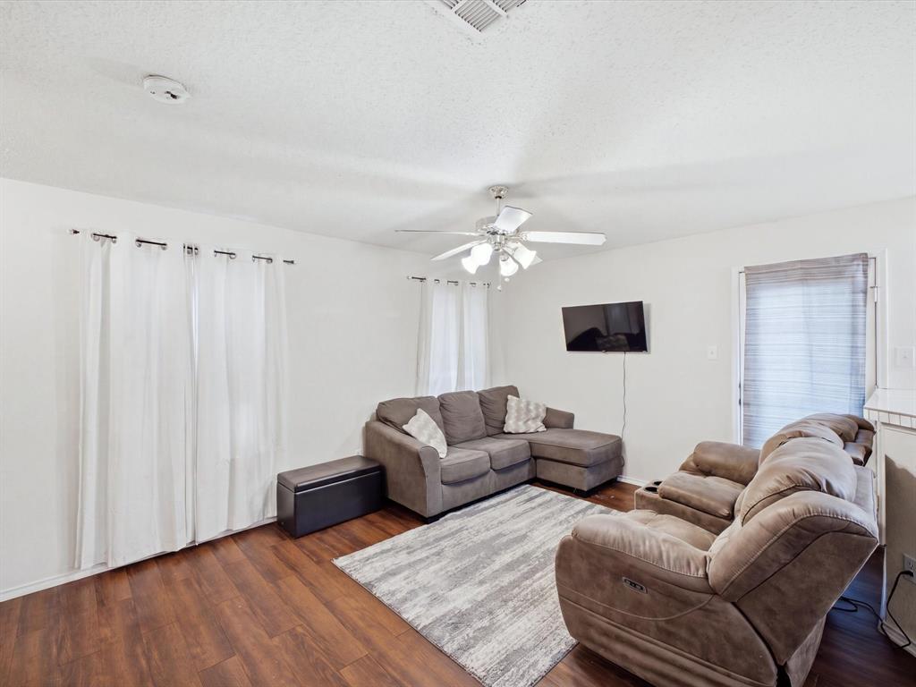 Wood-finish flooring throughout, complemented by a ceiling fan with integrated lighting