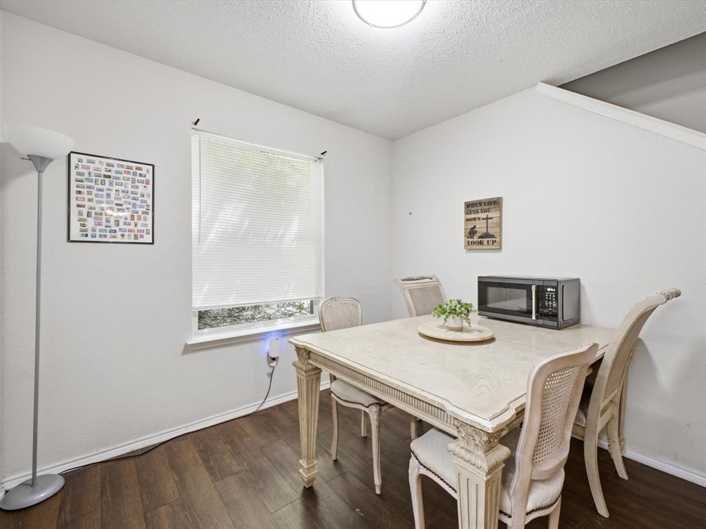 Wood-finish flooring, white painted walls, and a window with blinds