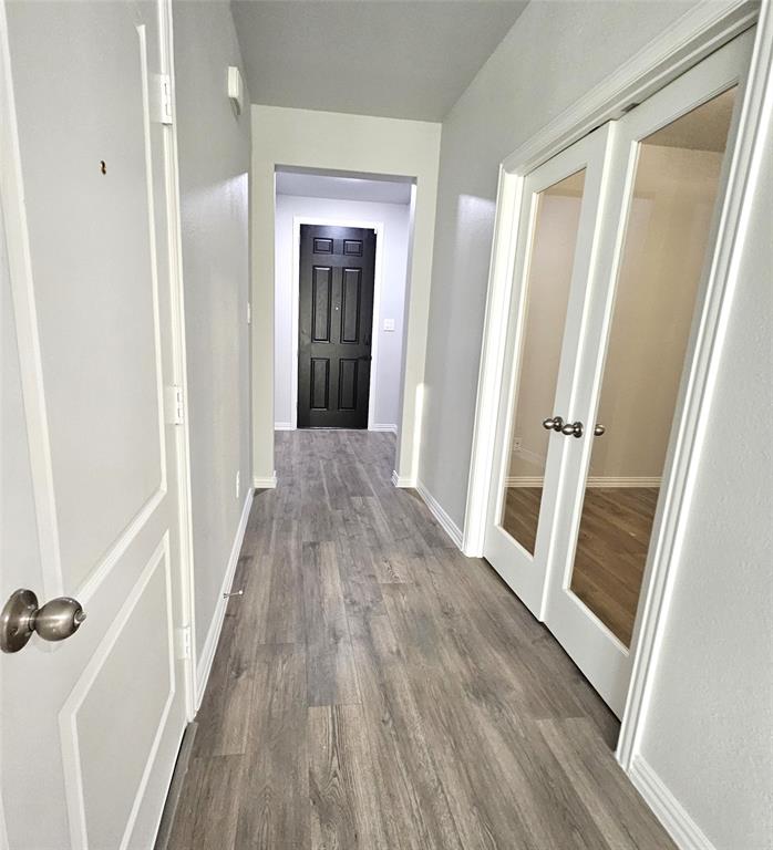Wood-finish flooring throughout, bright white walls, and paneled doors