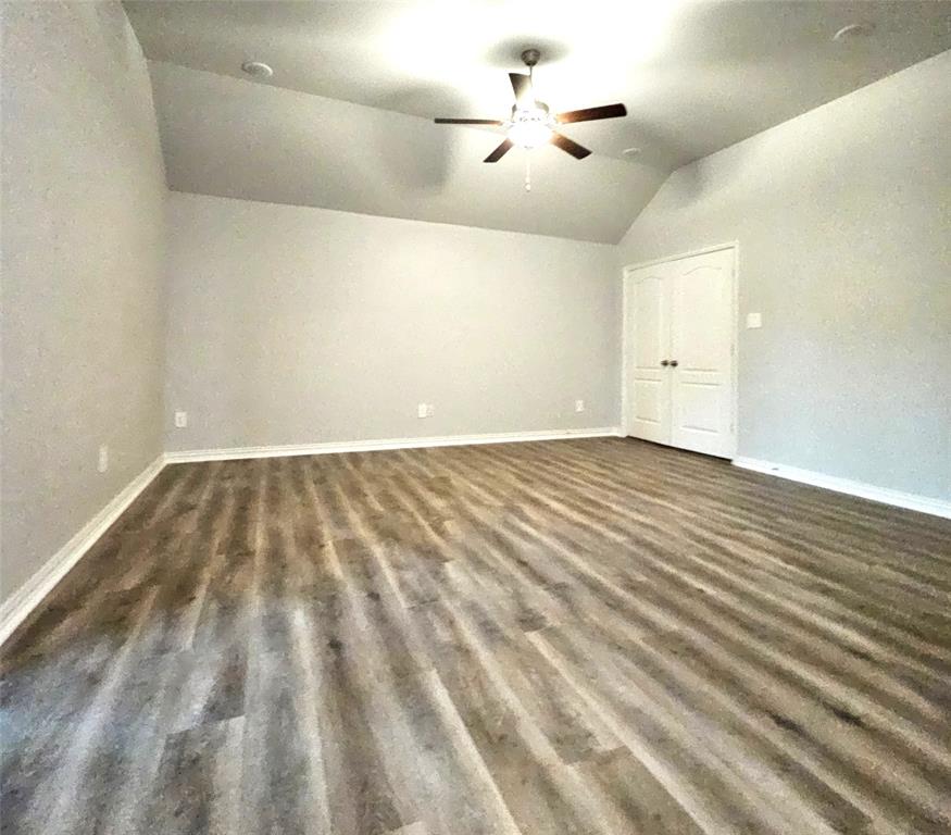 Vaulted ceiling with a ceiling fan, wood-finish flooring, recessed lighting, and double-panel doors