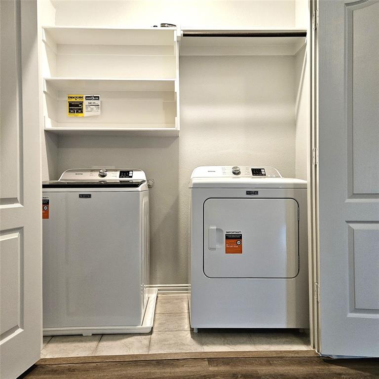 Dedicated laundry area with built-in shelving, a clothes rod, and tile flooring