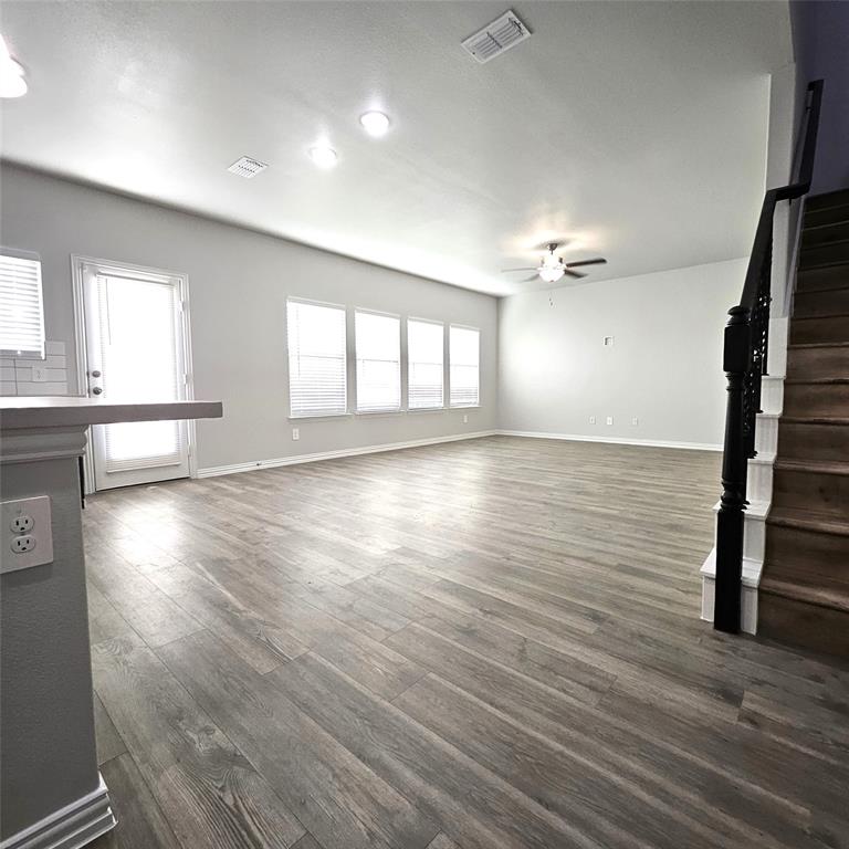 Spacious living area featuring wood-finish flooring, recessed lighting, and a ceiling fan