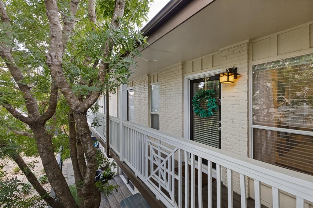 Painted brick exterior with a balcony featuring white railing