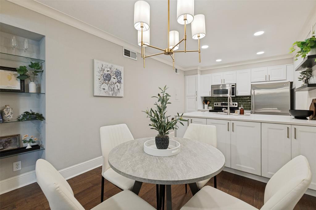 Kitchen featuring white cabinetry, stainless steel appliances, dark green subway tile backsplash, and light countertops