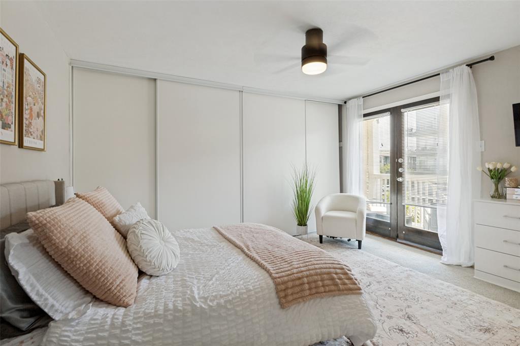 Full-height sliding closet doors, ceiling fan with integrated lighting, wood-finish French doors, and light-colored carpeting