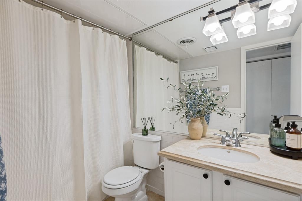 Vanity with an integrated sink, a polished chrome faucet, under-cabinet storage, and a light-toned countertop