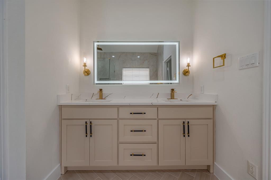 Dual vanity with integrated sinks, quartz countertops, and gold-finish fixtures