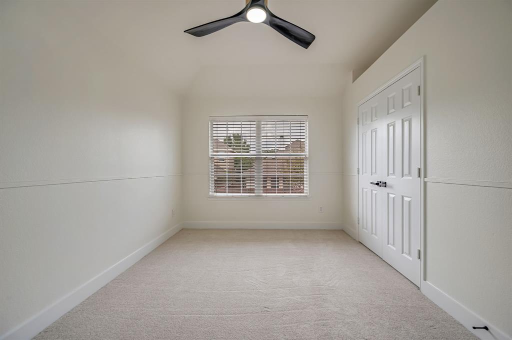 Neutral tone carpet with window blinds, a modern ceiling fan, and a paneled closet door