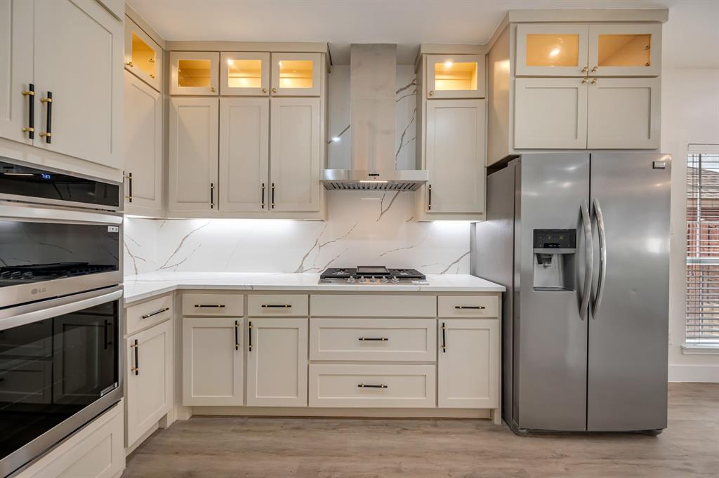 Kitchen featuring brand new shaker cabinetry, stainless steel appliances, white countertops, and a full-height quartz backsplash