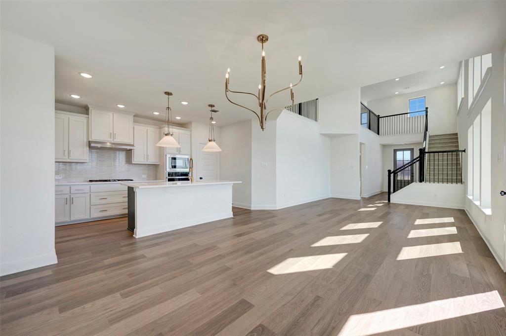 Open-concept living area featuring wood-finish flooring and high ceilings