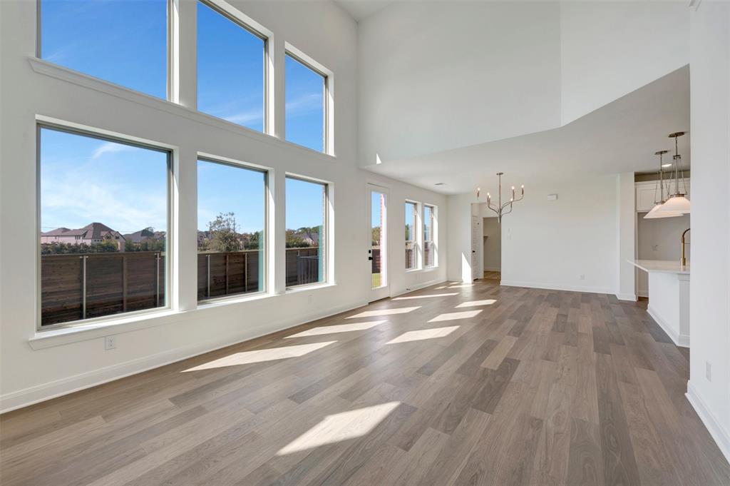 Vaulted ceilings above a spacious room with wood-finish flooring