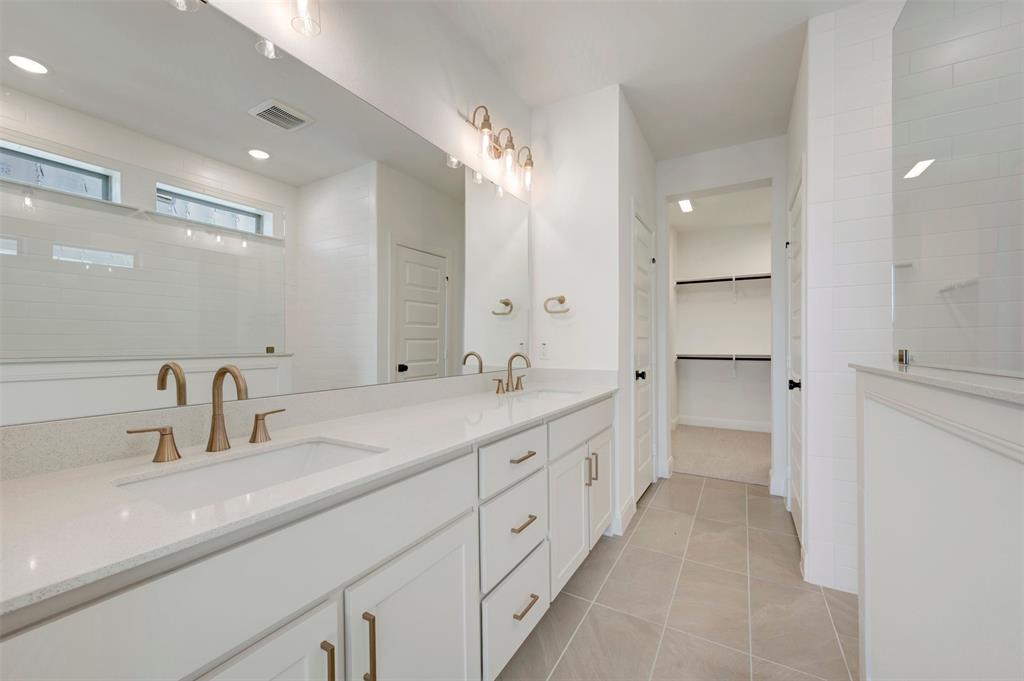 Dual vanity with undermount sinks, bronze finish fixtures, and white cabinetry Dual vanity with undermount sinks, bronze finish fixtures, and white cabinetry
