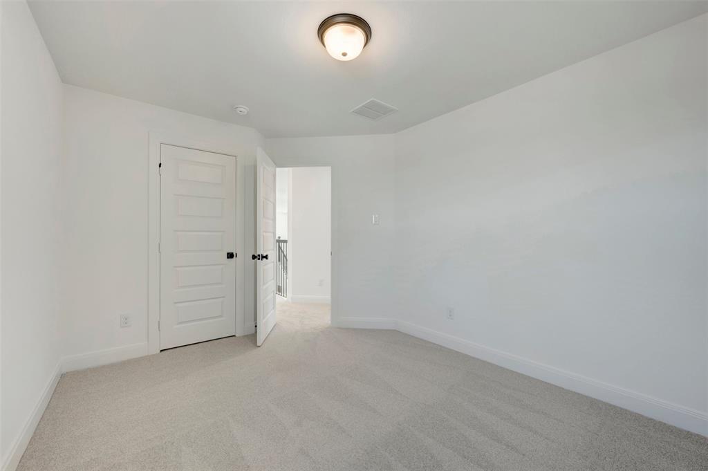 Neutral paint palette with light-colored carpet flooring, recessed lighting, and a paneled door with dark hardware