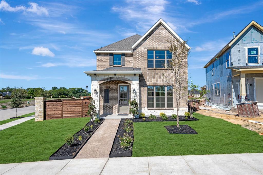 Brick facade, stone accents, arched entry, manicured landscaping, and a paved walkway Brick facade, stone accents, arched entry, manicured landscaping, and a paved walkway