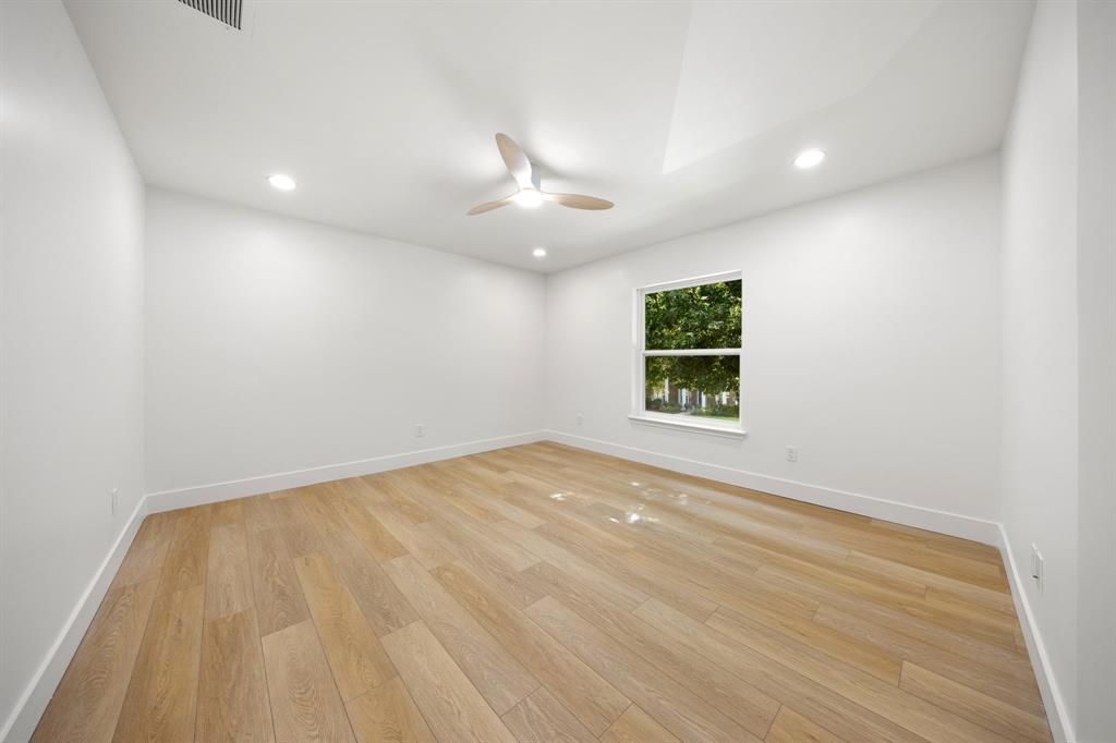 Bright room featuring wood-finish flooring, a contemporary ceiling fan, recessed lighting, a single window, and a vaulted ceiling