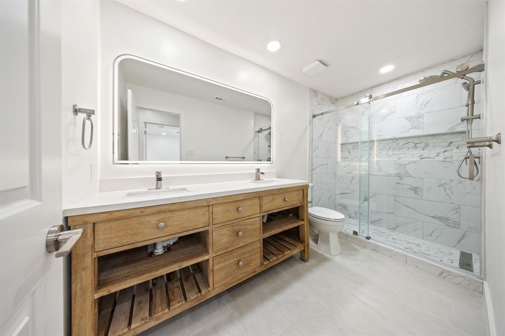 Double vanity with wood-finish cabinetry, white countertop, and dual undermount sinks