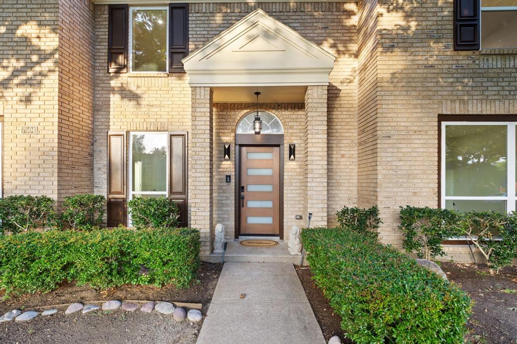 Brick exterior with a covered entry featuring a transom window above the front door