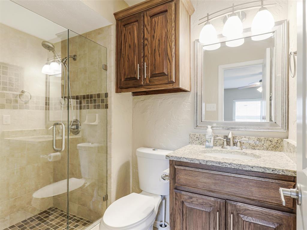 Walk-in shower with clear glass enclosure and mosaic tile accent