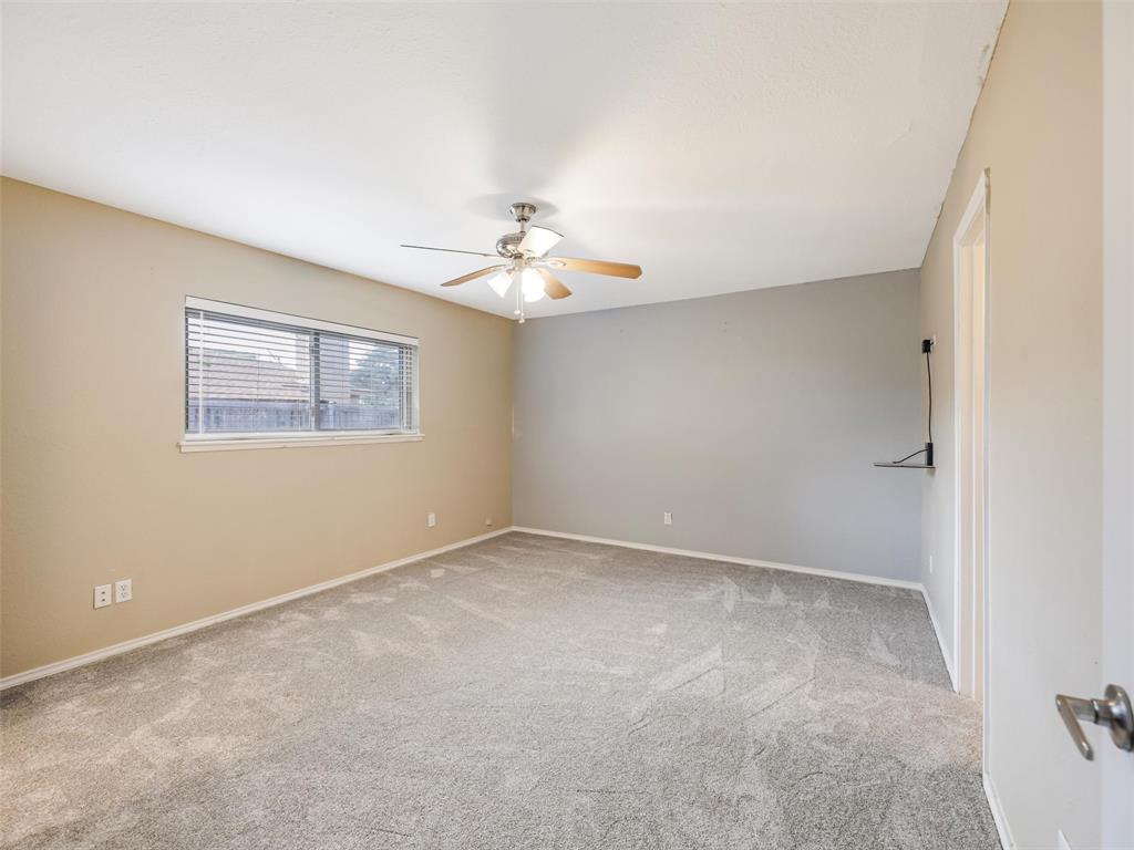 Wall-to-wall carpeting, window with blinds, ceiling fan with light fixture, and neutral wall tones