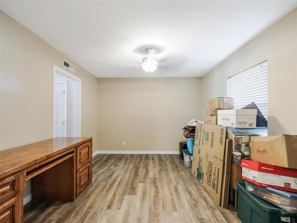 Wood-finish flooring, neutral wall tones, recessed lighting, and a built-in wood desk