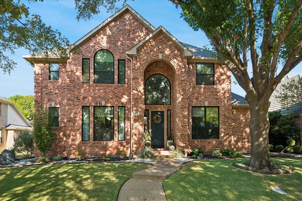 Brick facade with arched entryway and symmetrical landscaping