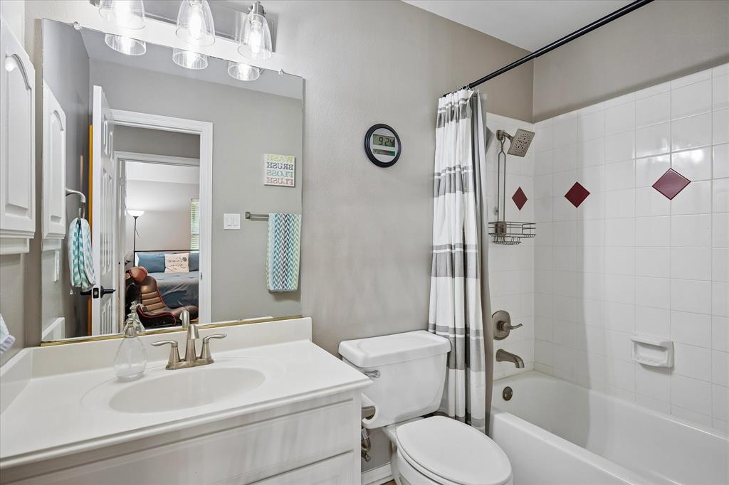 White vanity with integrated sink, brushed nickel faucet, large mirror, and three-light fixture