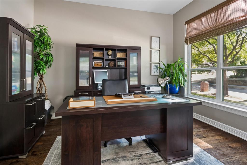 Large picture window with natural light, wood-finish flooring, neutral wall paint, and white trim
