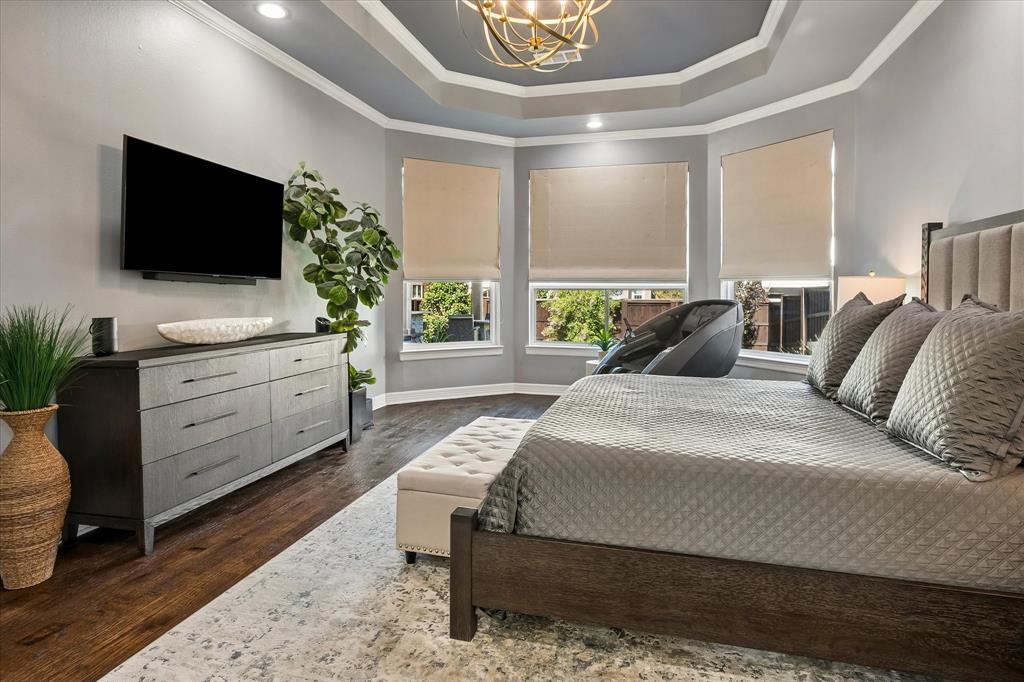 Tray ceiling with crown molding, recessed lighting, and a decorative light fixture