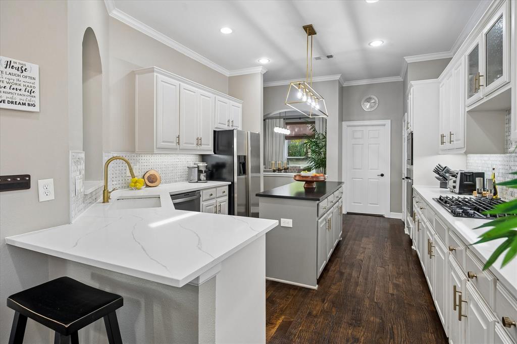 Kitchen featuring white cabinetry, light-toned countertops, a central island, wood-finish flooring, and recessed lighting