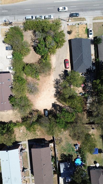 Property featuring a large lot, established trees, and a detached structure with a dark shingle roof Property featuring a large lot, established trees, and a detached structure with a dark shingle roof