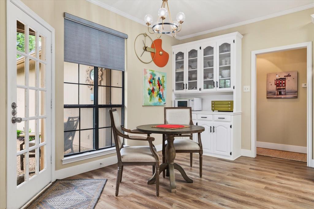 Wood-finish flooring, built-in display cabinetry, and a multi-pane glass door