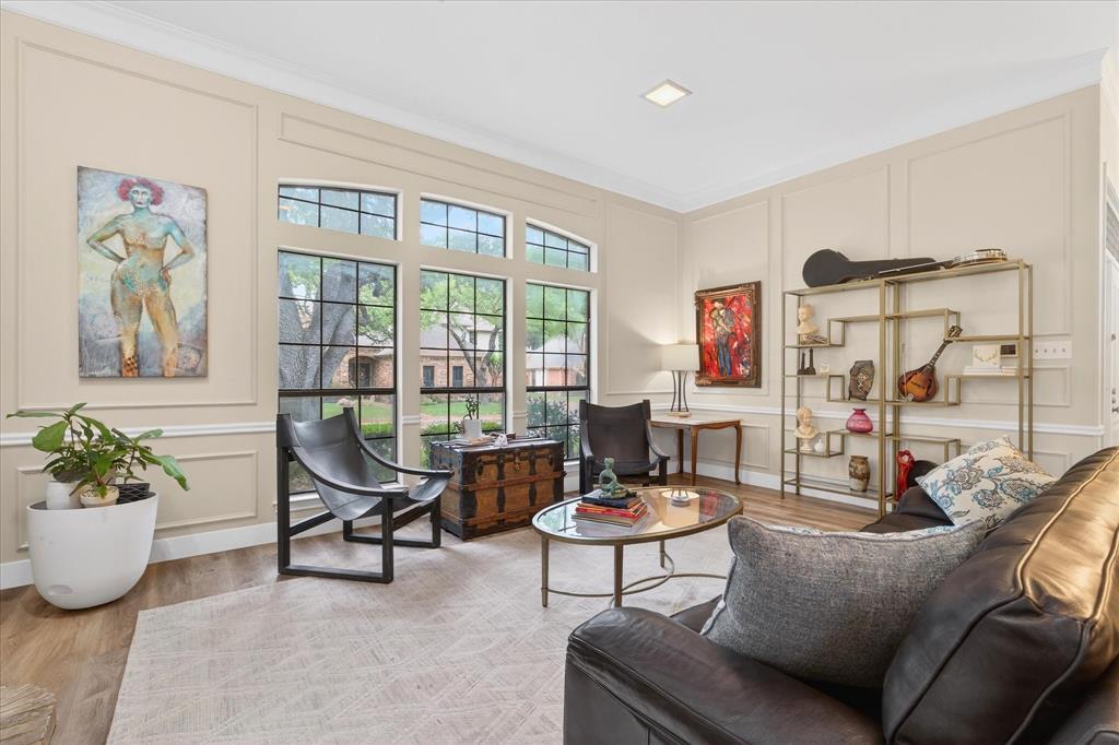Tall windows with arched transom, wood-finish flooring, recessed lighting, crown molding, and wall paneling