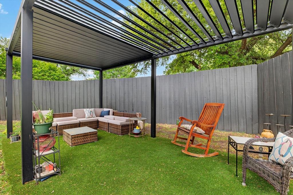 Pergola with adjustable louvered roof, artificial turf, and wood privacy fence