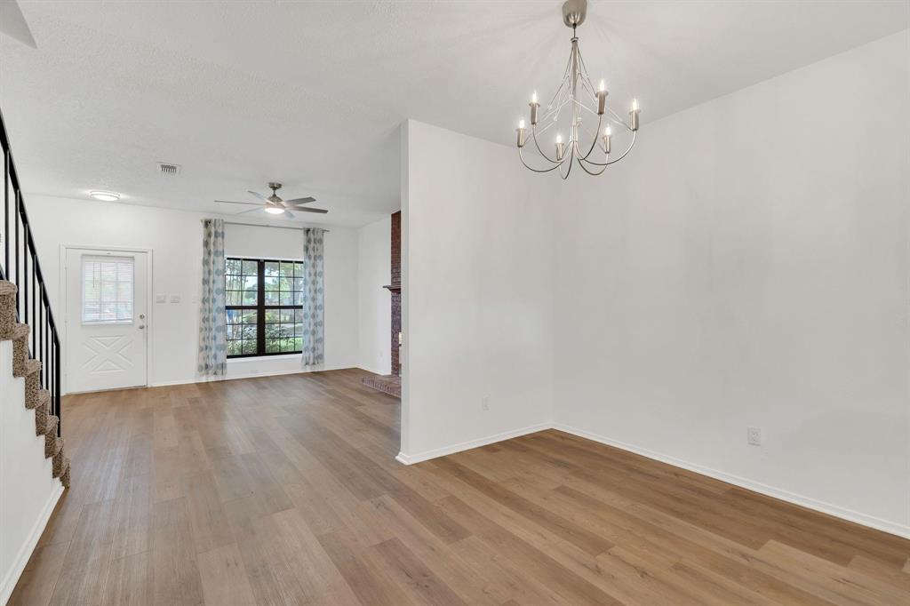 Wood-finish flooring throughout, bright white walls, and a multi-pane window with a light-colored window treatment