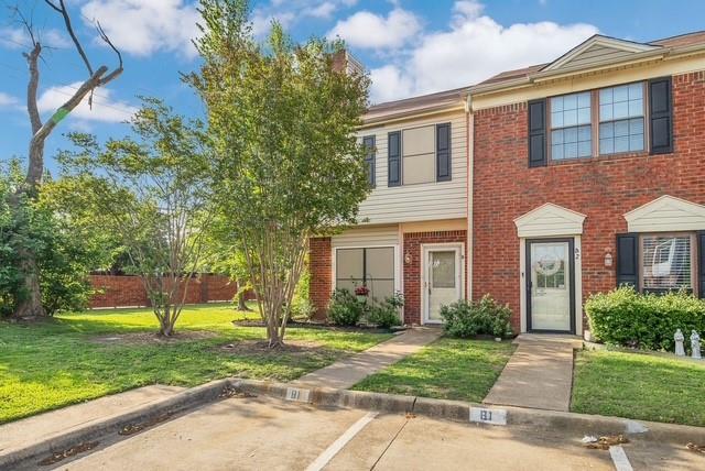 Brick and siding facade with shutters, manicured lawn, and paved walkways Brick and siding facade with shutters, manicured lawn, and paved walkways