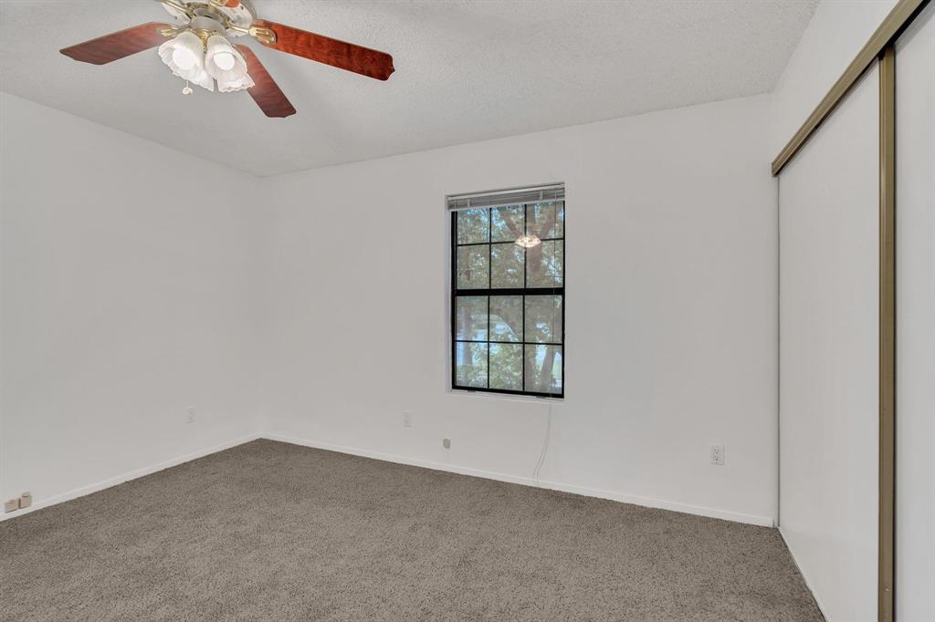 Recessed window with black gridded panes, ceiling fan with integrated lighting, textured ceiling, and sliding closet doors Recessed window with black gridded panes, ceiling fan with integrated lighting, textured ceiling, and sliding closet doors