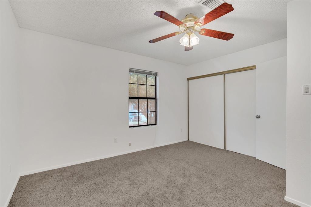 Room featuring a window, ceiling fan with light fixture, carpeted flooring, and sliding closet doors Room featuring a window, ceiling fan with light fixture, carpeted flooring, and sliding closet doors