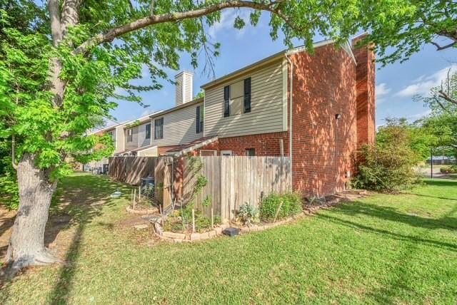 Wood privacy fence with garden beds, expansive green lawn, and mature trees Wood privacy fence with garden beds, expansive green lawn, and mature trees