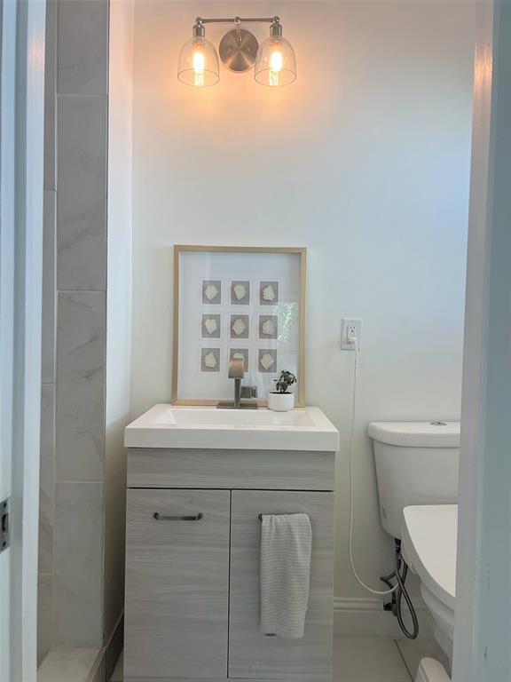 Vanity with integrated sink, wood-style cabinetry, and a single-handle faucet